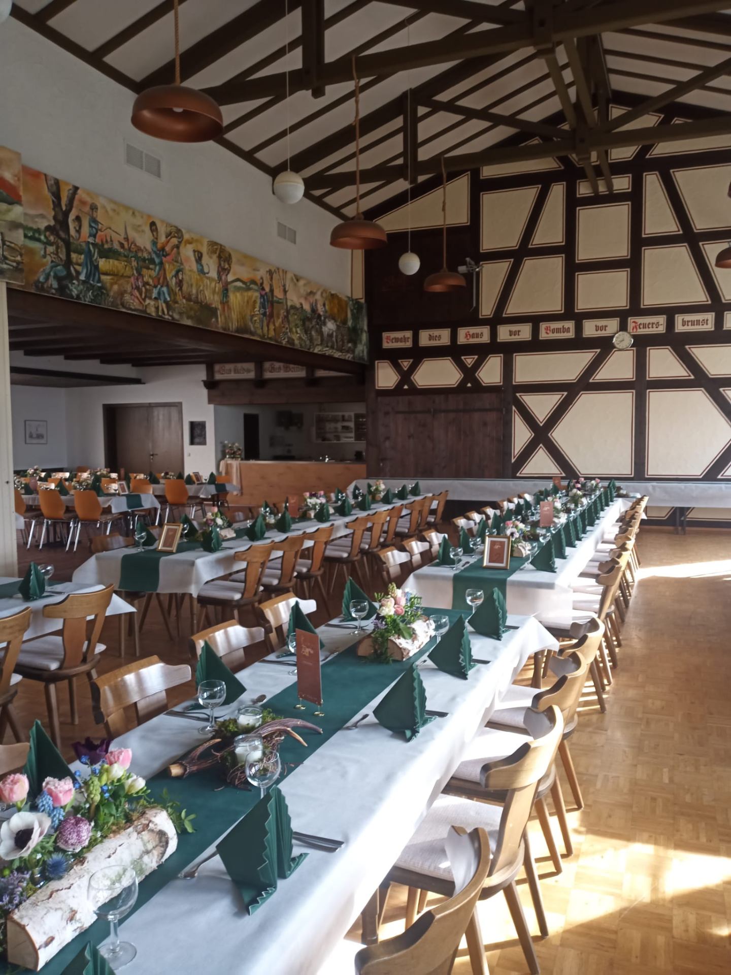 Festsaal mit Fachwerk-Wand und langen Tafeln